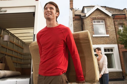 Specialist movers navigating stairs during a piano removal in Lambeth