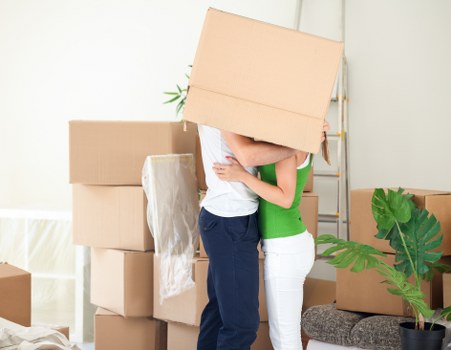 Movers using protective gear and lifting aids on a removal job