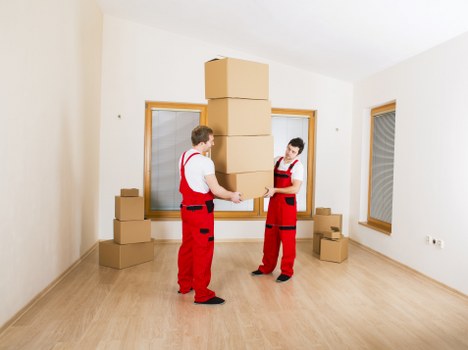 Removal staff using protective equipment while moving household items